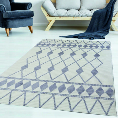 Matalanukkainen, eläväpintainen valkoinen Vivia Jolie-matto salmiakkikuviolla huoneen lattialla keskilattiamattona..