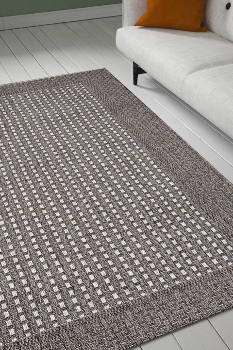 Nutrian värinen, yksinkertaisesti kuvioitu Dolce-matto olohuoneen lattialla. Matossa yksivärinen reunaboordi.
