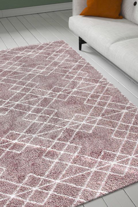 Rosan värinen, valkoisella hillitysti kuvioitu, pehmeänukkainen Mila Deco-matto olohuoneen lattialla.