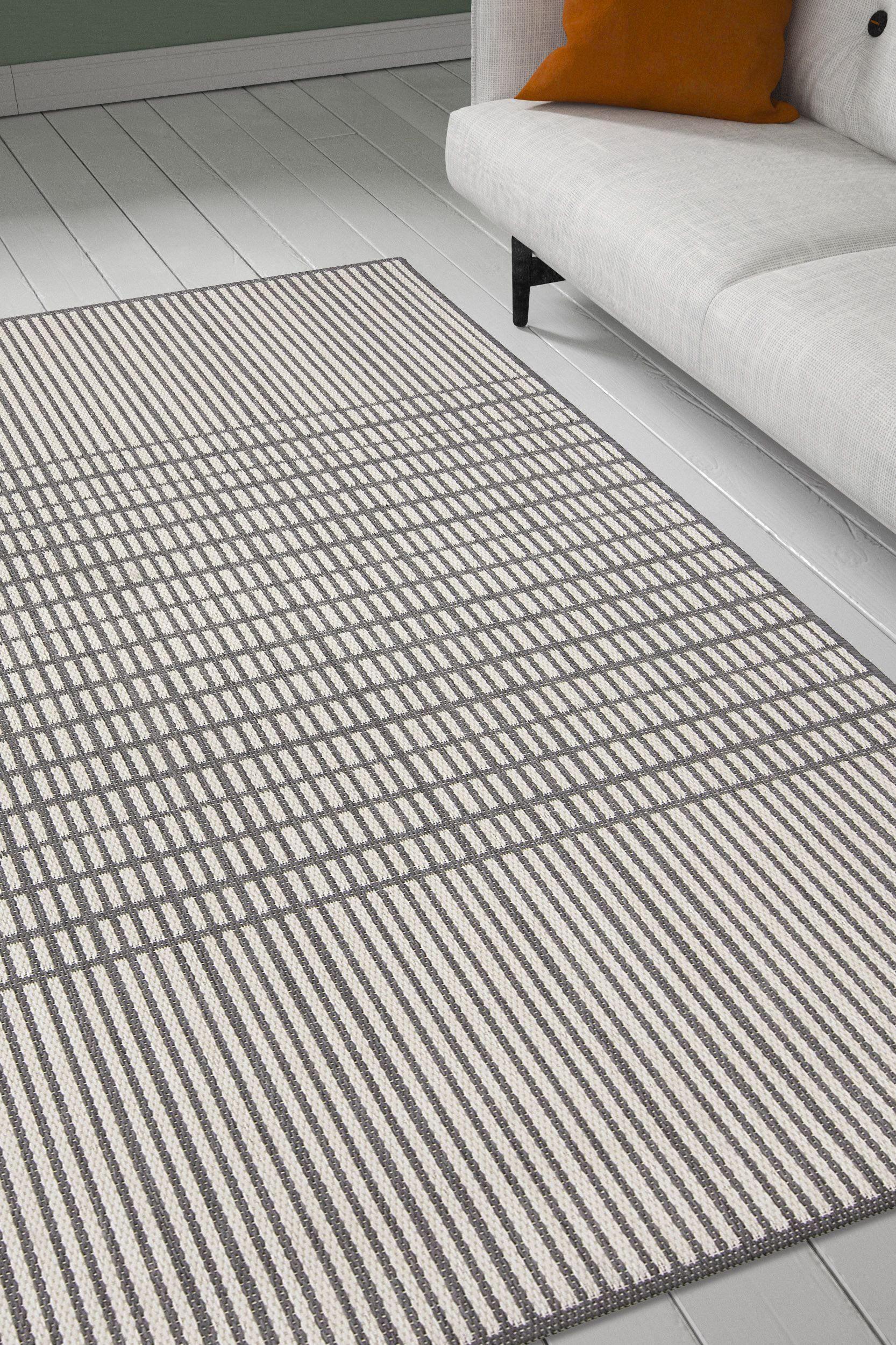 Sileäpintainen harmaa-valkoinen Verdi Lia matto olohuoneen lattialla. Skandinaavinen raidoitus.